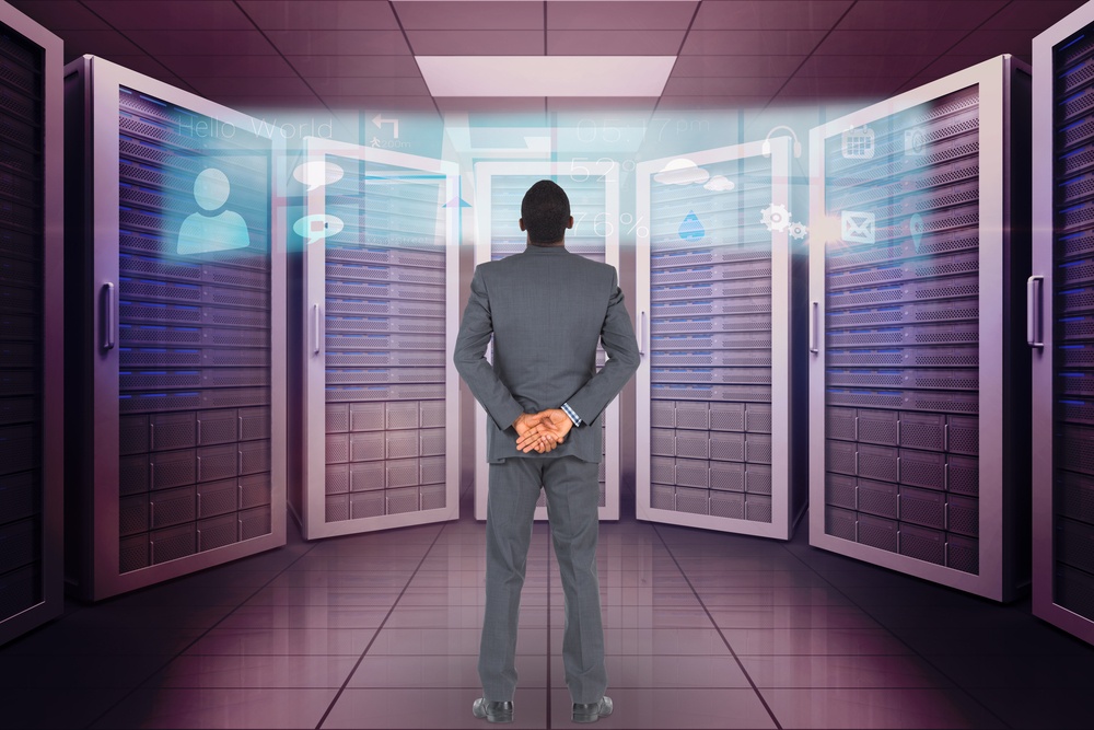 Young businessman standing with hands behind back against application interface